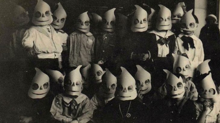 children with halloween masks smiling at camera